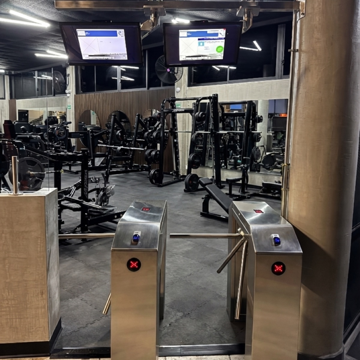 Torniquetes de acceso con pantallas de validación en el ingreso de un gimnasio